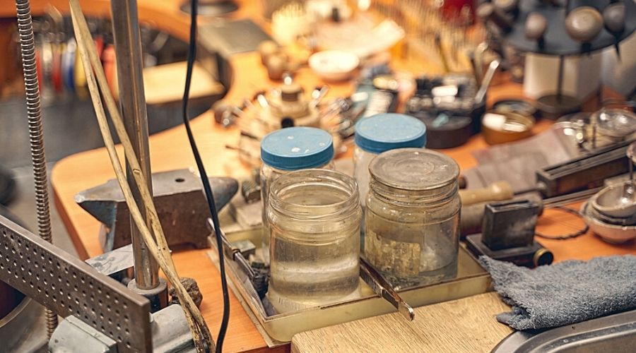 A workspace with glass jars and materials used for rhodium plating