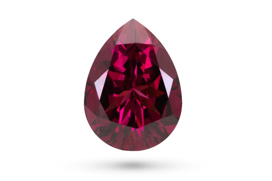 Red rhodolite garnet on a white background.