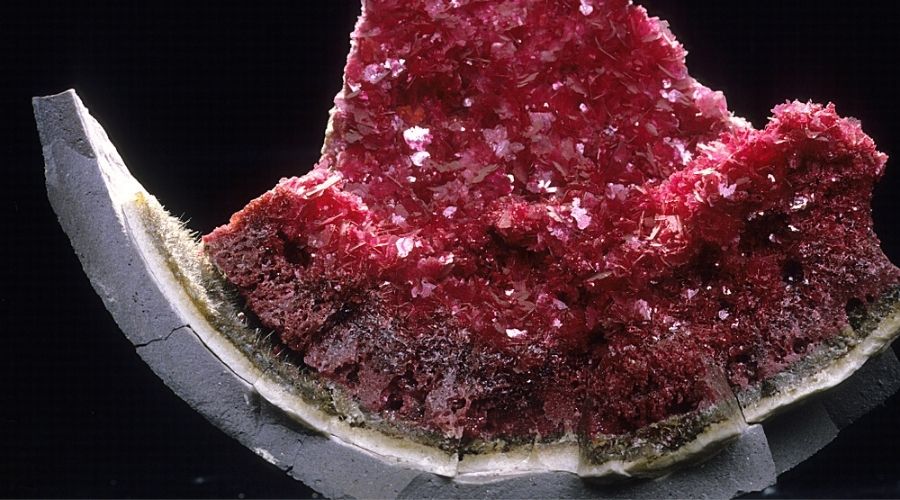 A rough synthetic ruby isolated against a black background