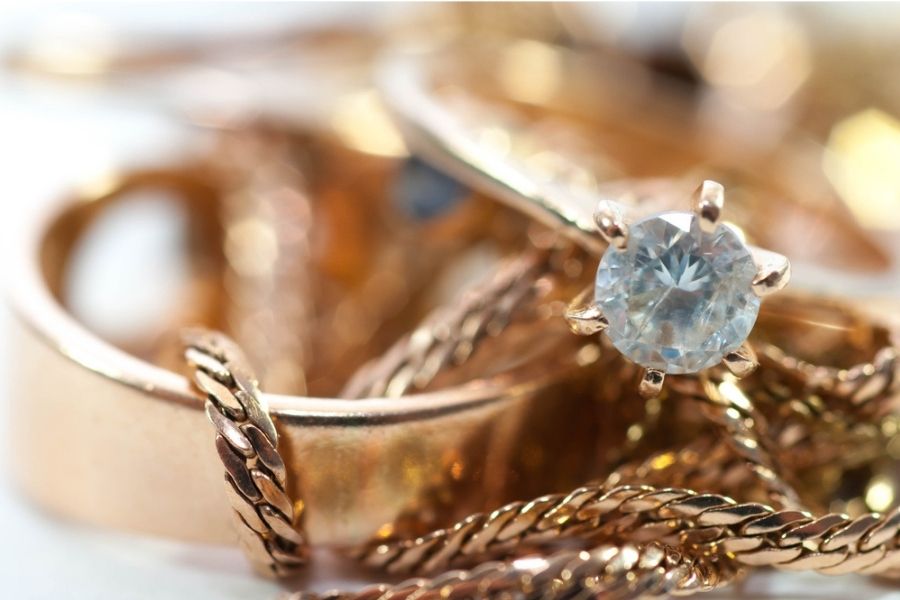 Close up o gold jewelry with gems on a white background