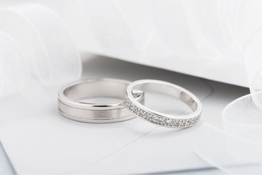 two silver engagement rings on table