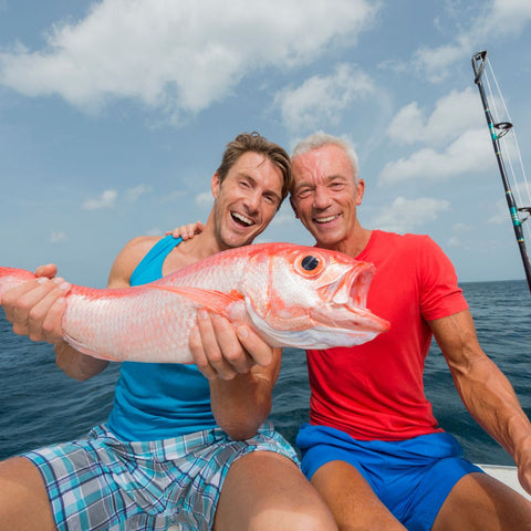 two guys happily holding up a saltwater fish
