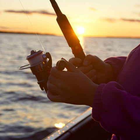 closeup of deep sea fisher using spinning reel