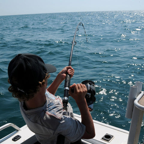 Young deep sea fisher reeling in a catch