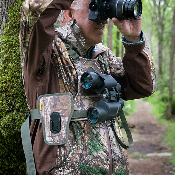 Man wearing a binocular harness while birding