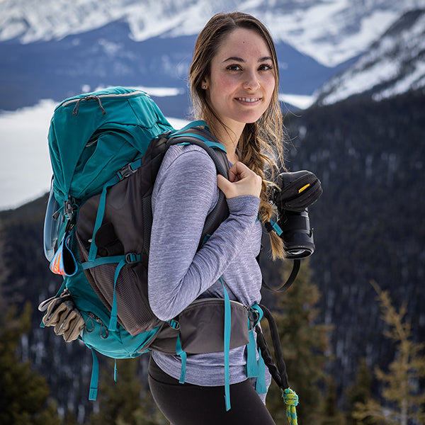 Woman wearing a hiking backpack and a camera harness