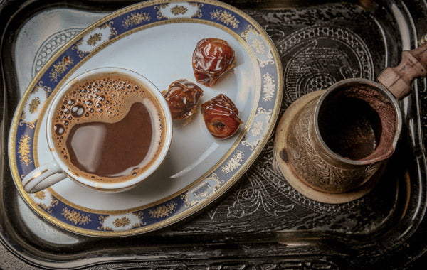 cup of coffee with dates on serving tray