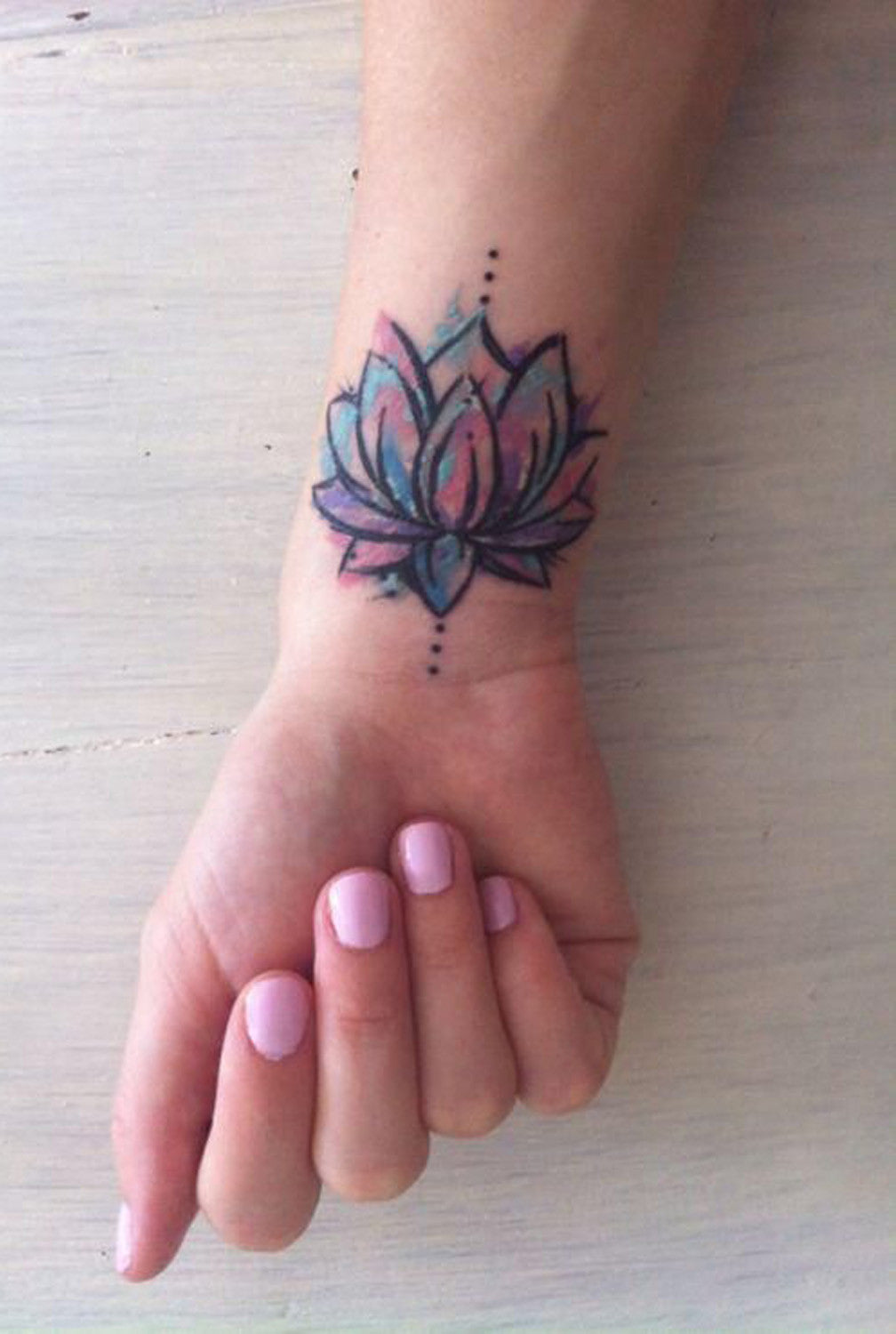 Watercolor Lotus Floral Flower Wrist Tattoo Ideas for Women at MyBodiArt.com 