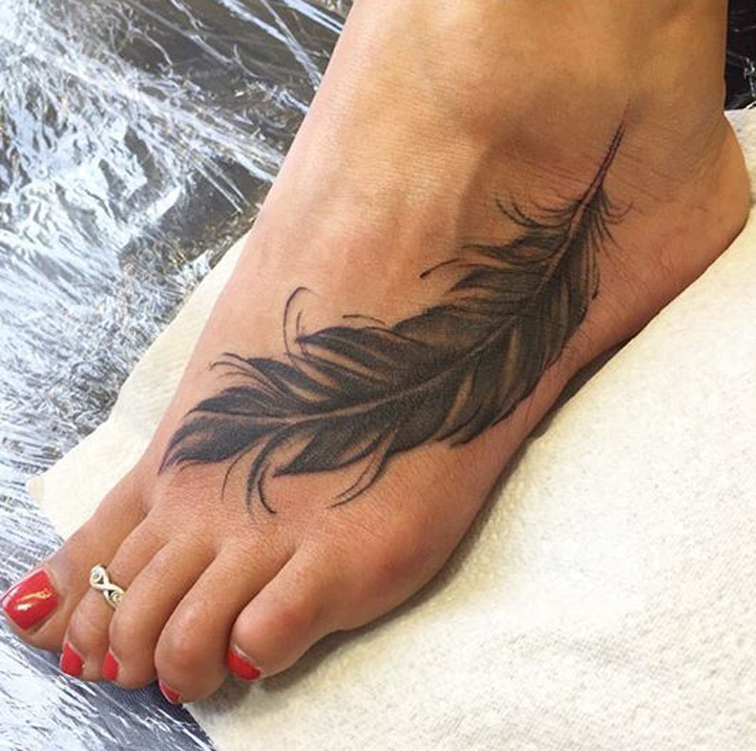 Black Feather Foot Tattoo Ideas at MyBodiArt.com 