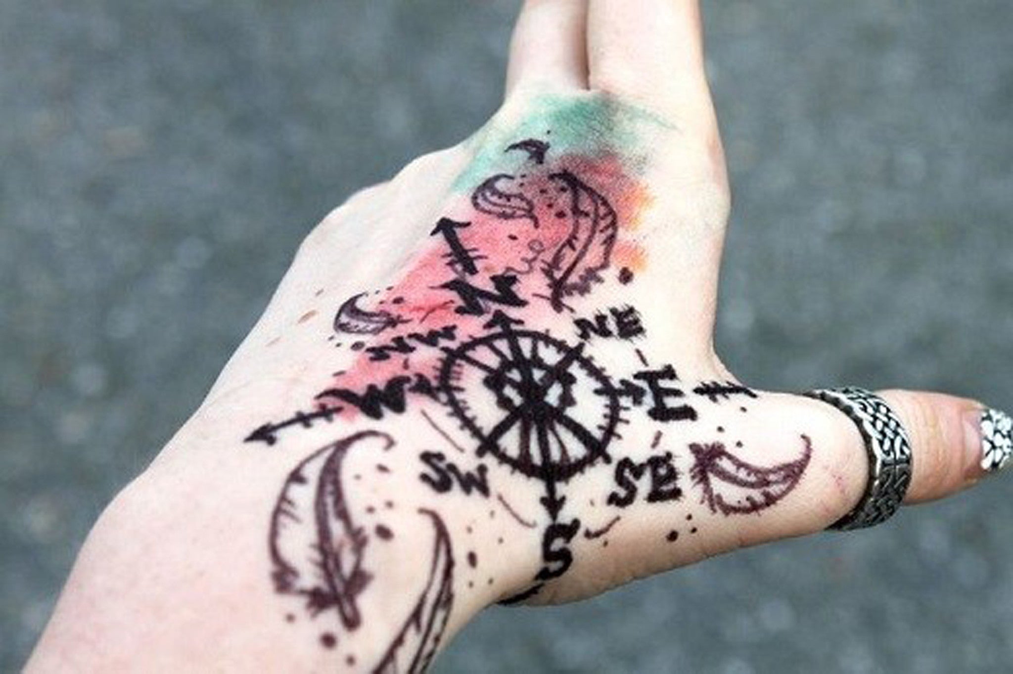 Graffiti Feather Compass Arrow Watercolor Hand Tattoo Ideas at MyBodiArt.com