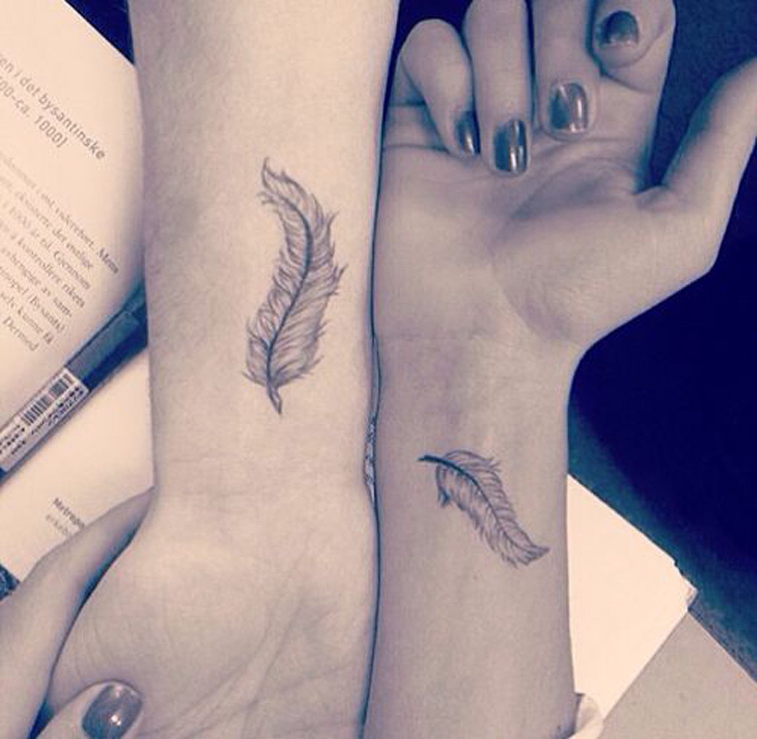 Cute Small Plume Feather Matching Couple Best Friends Wrist Tattoo Ideas for Women at MyBodiArt.com 