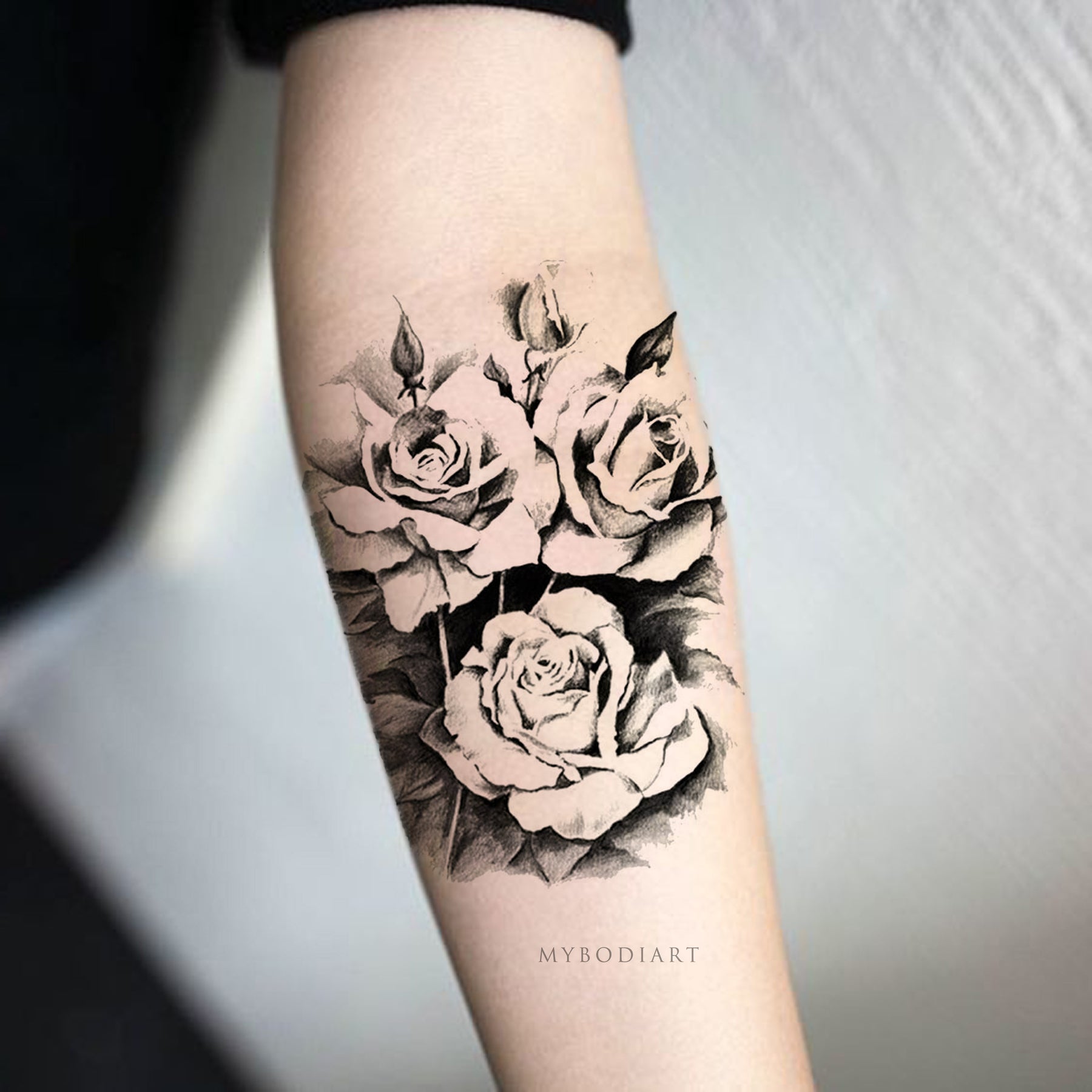 Sketchy black rose tattoo on the left forearm