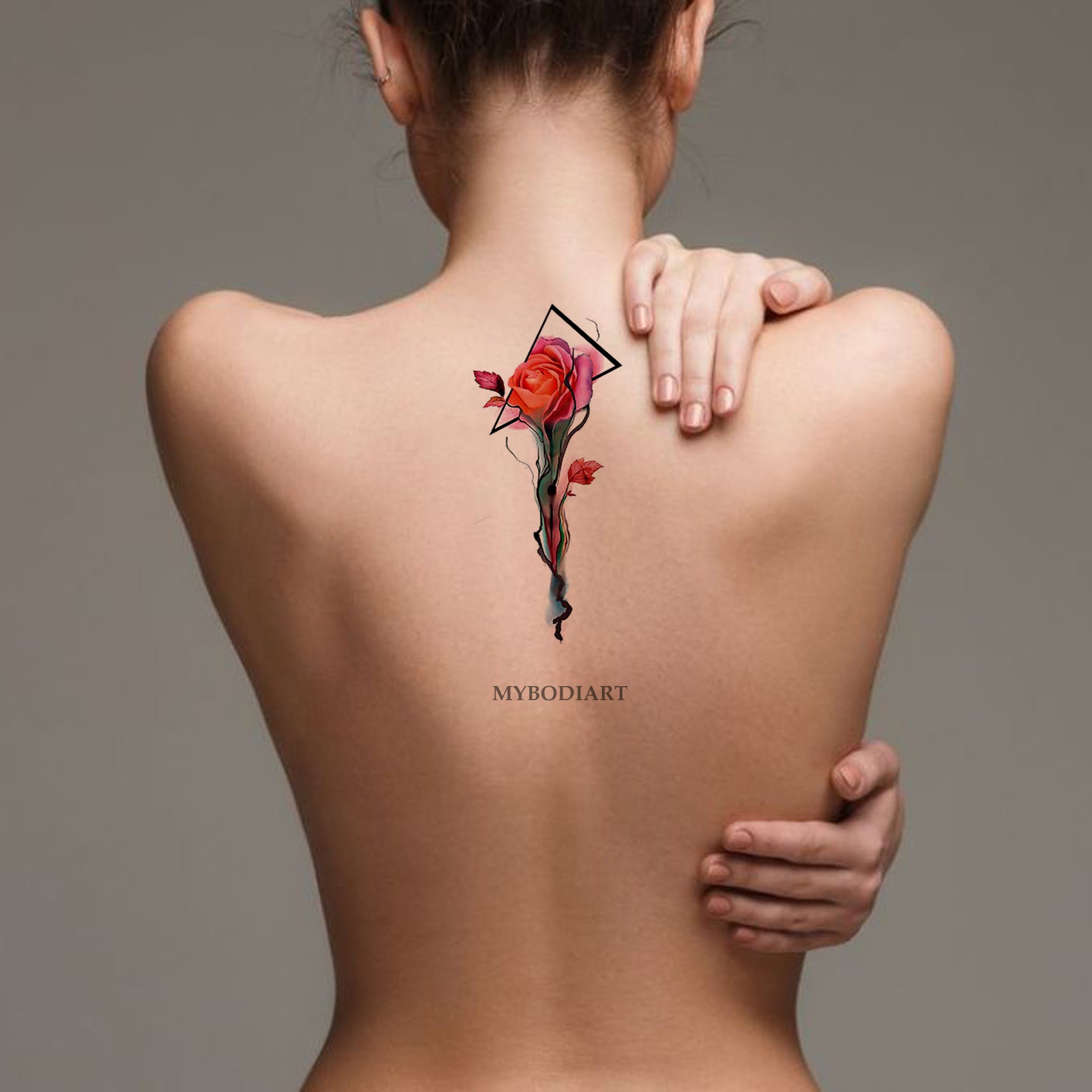 Minimalistic ornament tattooed on the back done in red