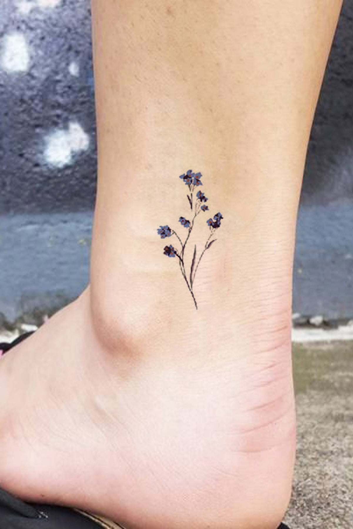 Tiny flower tattoo on the ankle