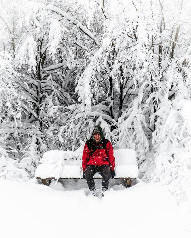Fur Hat Canada Man sitting trail bench winter snow 