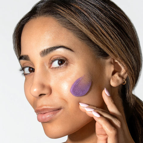 A woman with a swatch of ReSURFACE polish on her cheek