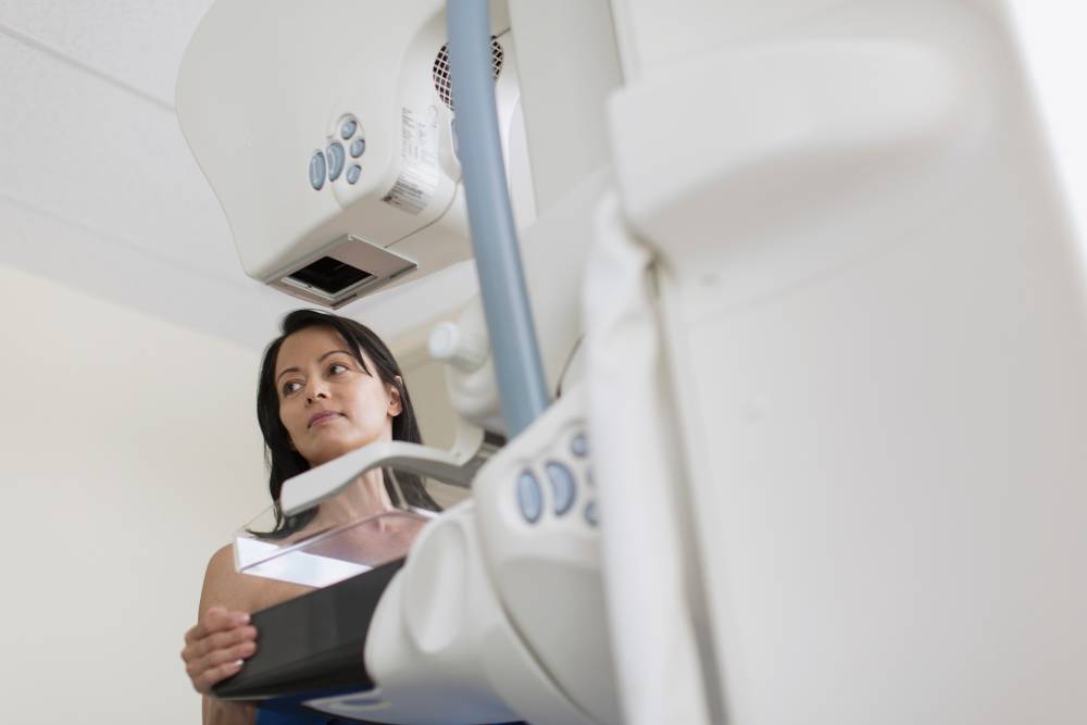 Middle-aged woman getting mammogram and looking to the side