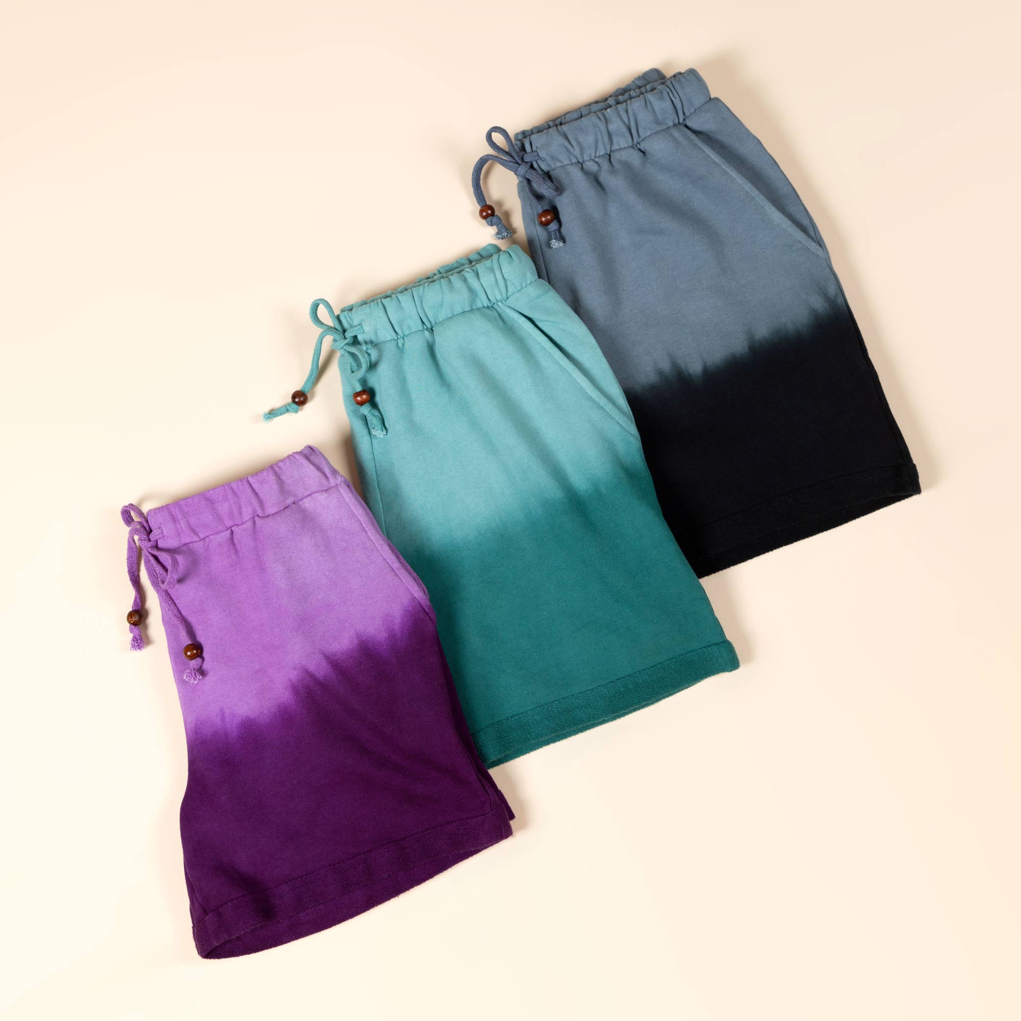 Three pairs of tie-dye shorts foldered in half and laid flat