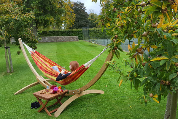 Lying in hammock with stand with tennis court in background