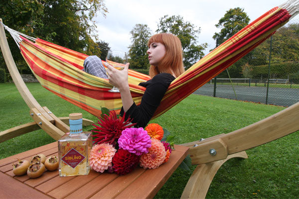 Woman in hammock with dahlias on side table
