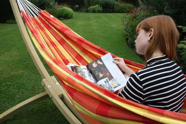 Woman reading magazine in hammock in garden