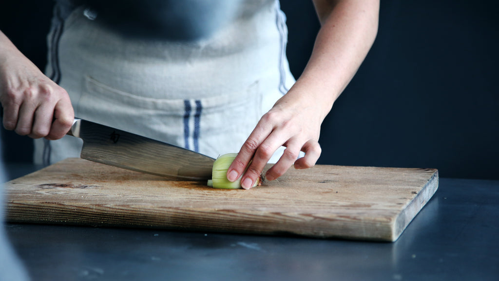 What is a santoku knife: A chef chopping an onion
