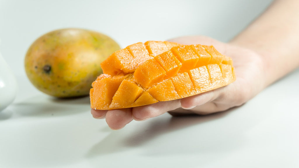 How to cut a watermelon: scored mango in a person's hand