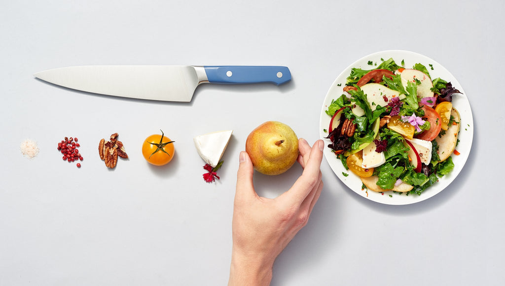 Chopped vs. diced: Chopped ingredients, a knife, a salad, and a hand holding a pear