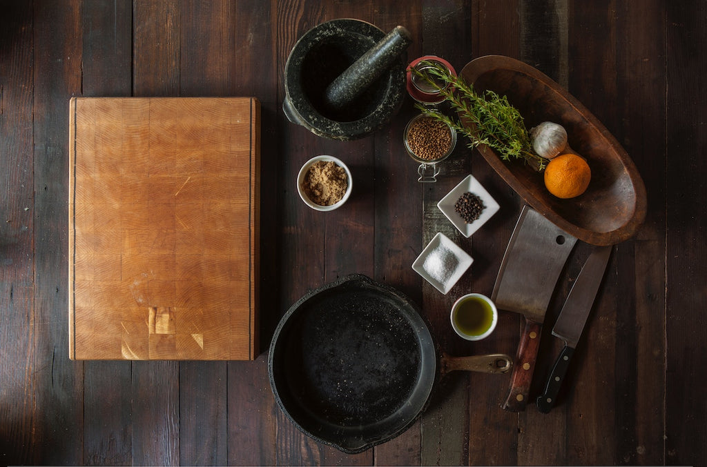 A recipe book, ingredients, and two types of kitchen knives