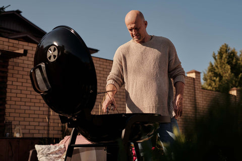 Persona che si presta a cucinare sul barbecue pronto