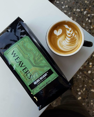 Photo of a bag of Weaver's Hackers Delight Coffee and a latte art cup of coffee