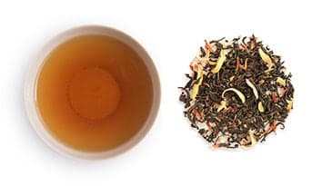 Mango Black Tea brewed in a Cup and Loose leaf tea next to the cup.