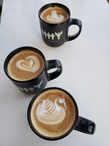 3 black mugs with 3 different latte art in each mug