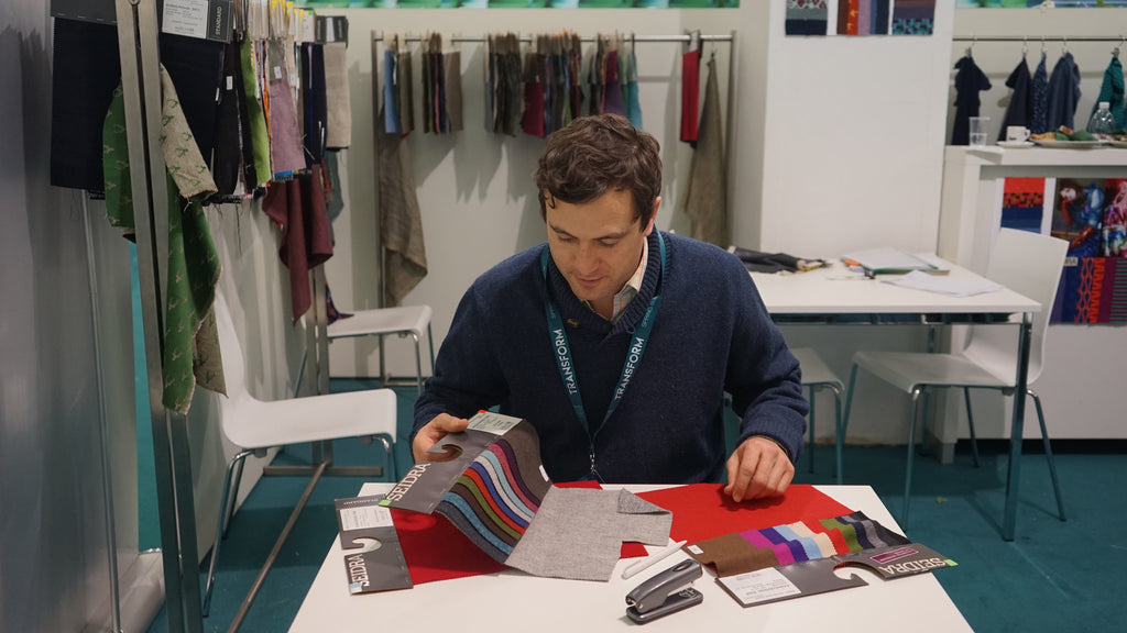 Robert W. Stolz at the Munich textile show examining loden wool fabrics from the Austrian weaver Seidra