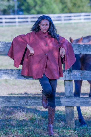 young woman wearing Robert W. Stolz poncho in cherry red