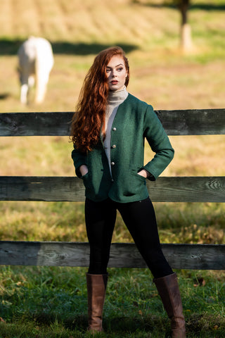 young women with red hair standing in front of pasture wearing green boiled wool jacket from Robert W. Stolz