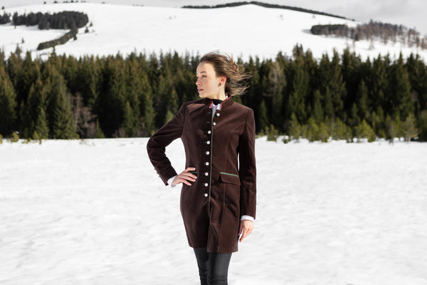 young woman wearing an austrian jacket in a snowy field