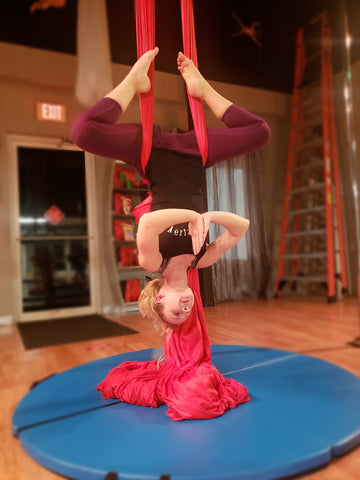 Girl doing a Buddha Pose in our Red Aerial Silks