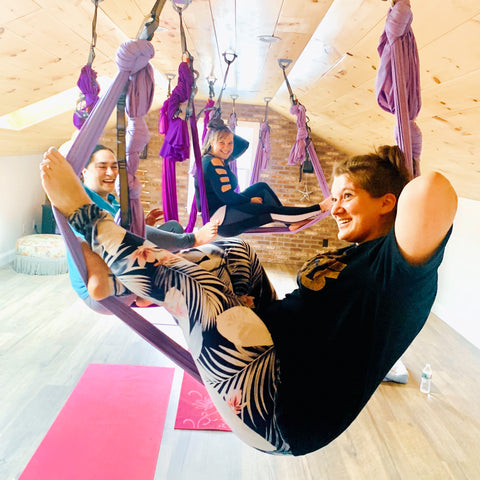 Girls having fun while hanging in their aerial hammocks