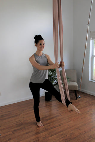 Girl practicing aerial yoga at home