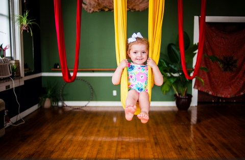 Child Swinging on a Yellow Yoga Hammock