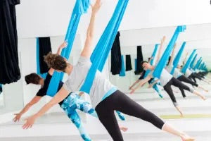 A class of aerial teachers doing aerial poses.