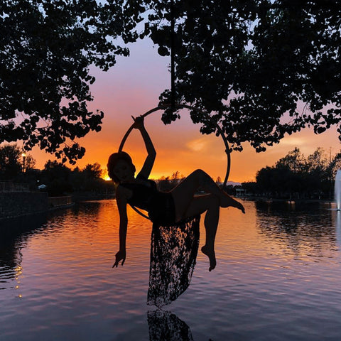 Girl resting on her aerial hoop/lyra while watching the sunset