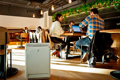 Air purifier inside a cafe surrounded by people