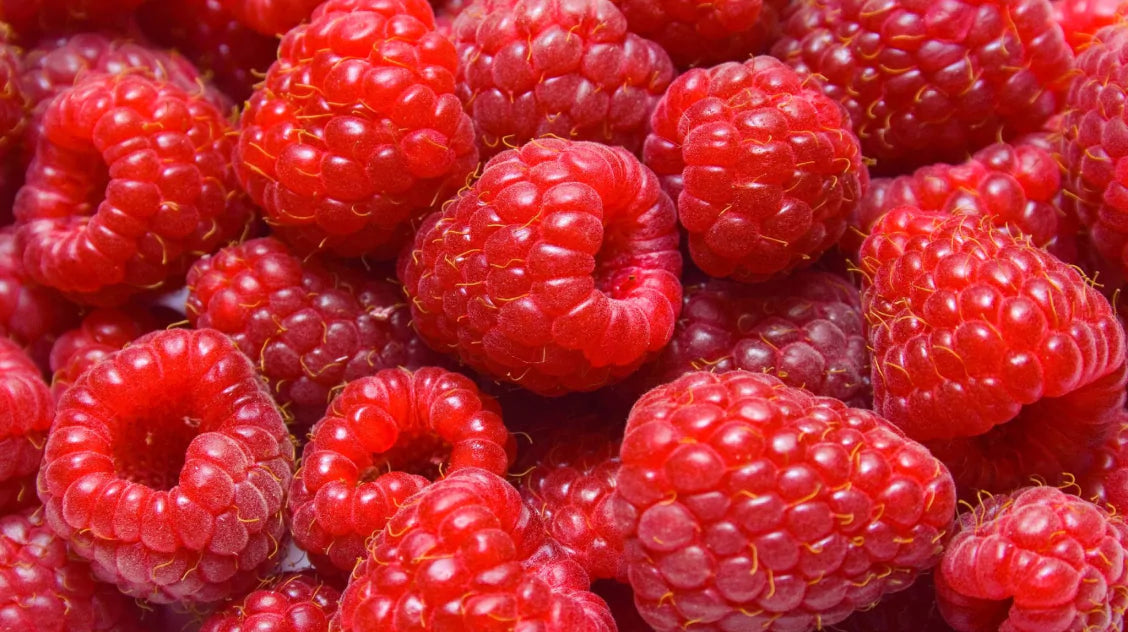 Close-up of fresh red raspberries with detailed texture.