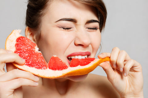 woman eating sour grapefruit