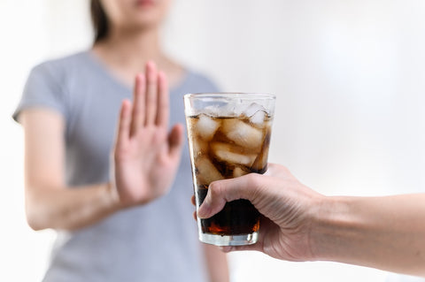 woman refusing to drink soda