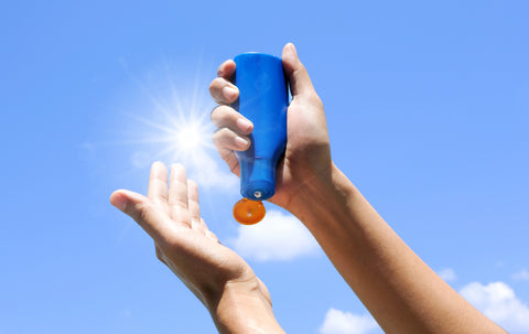 woman with sunscreen in hand