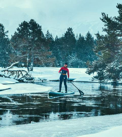 femme qui fait du stand up paddle en combinaison neoprene hiver
