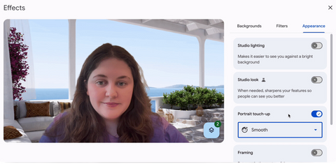 A screenshot of a user enabling portrait touch-up mode in Google Meet on the web. The user is in the “Effects” menu and is looking at the “Appearance” tab. They have clicked the toggle next to “Portrait touch-up” to turn it on and selected the “Smooth” mode from the dropdown menu. On the left-hand side of the screenshot, the user’s self view is displayed and their appearance is subtly enhanced.